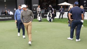 Rory McIlroy walks past Patrick Reed